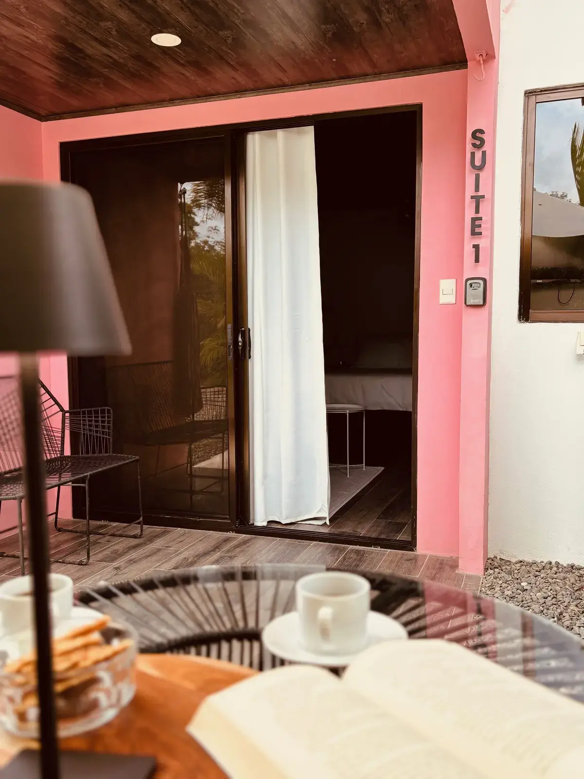 Exterior view of Suite 1 with pink walls and tropical plants